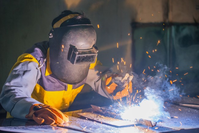 Spawacz podczas pracy — produkcja artykułów metalowych